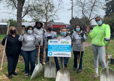 Volunteers with shovels holding a sign