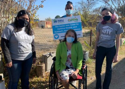 Volunteers posing with a homeowner