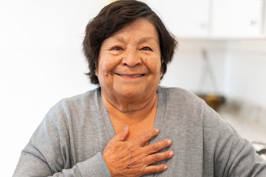 Smiling woman with a hand over her heart