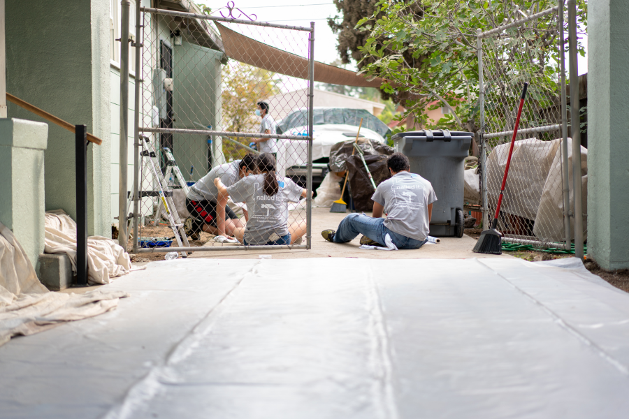 Volunteers sitting on the ground while they repair items