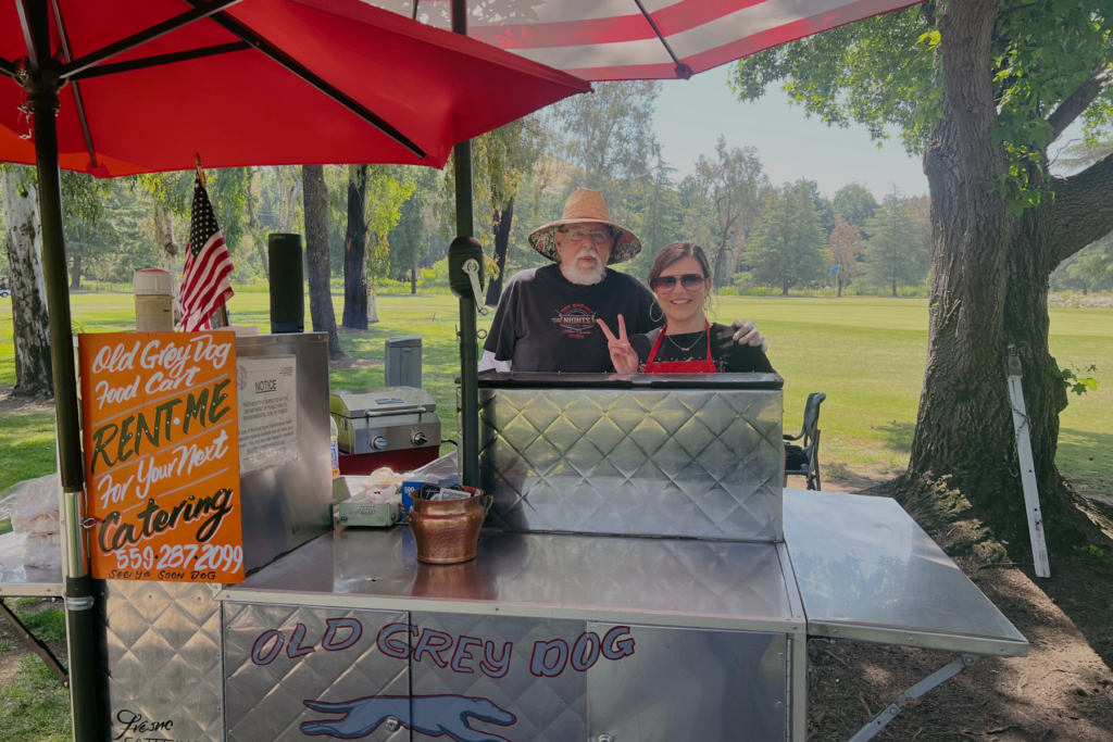 T4K Food A man and a woman behind a hot dog cart.